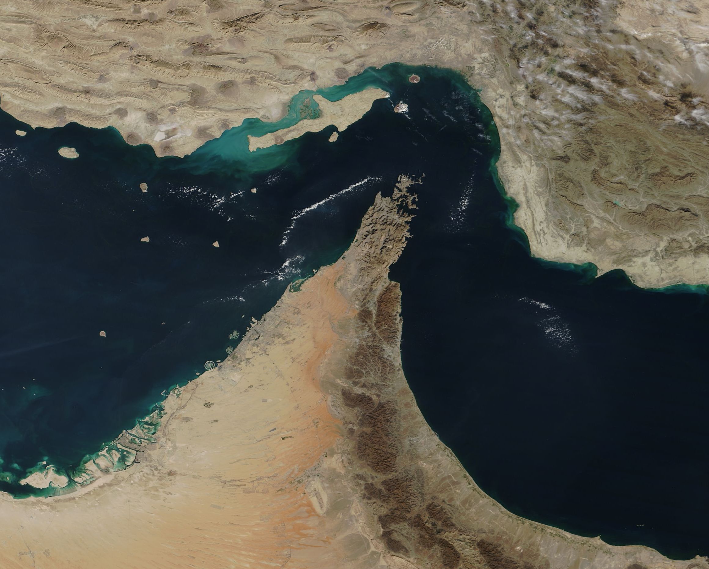 Characterized by barren, rugged limestone peaks rising up to 2,000 meters (6,500 feet) to form dramatic, fjord-like coastal inlets, the Musandam Peninsula juts directly into the strategic Strait of Hormuz, which connects the Persian Gulf with the Gulf of Oman between Iran, Oman, and the United Arab Emirates. As a political exclave of Oman separated from the rest of its country by the UAE, the peninsula's northernmost city of Khasab sits just 65 kilometers (40 miles) across the water from the Iranian city of Bandar Abbas. The local economy is driven primarily by traditional industries like fishing, agriculture, and shipbuilding. This striking geography and its surrounding waters were beautifully captured in a true-color image by the MODIS instrument on NASA’s Terra satellite on December 6, 2018.